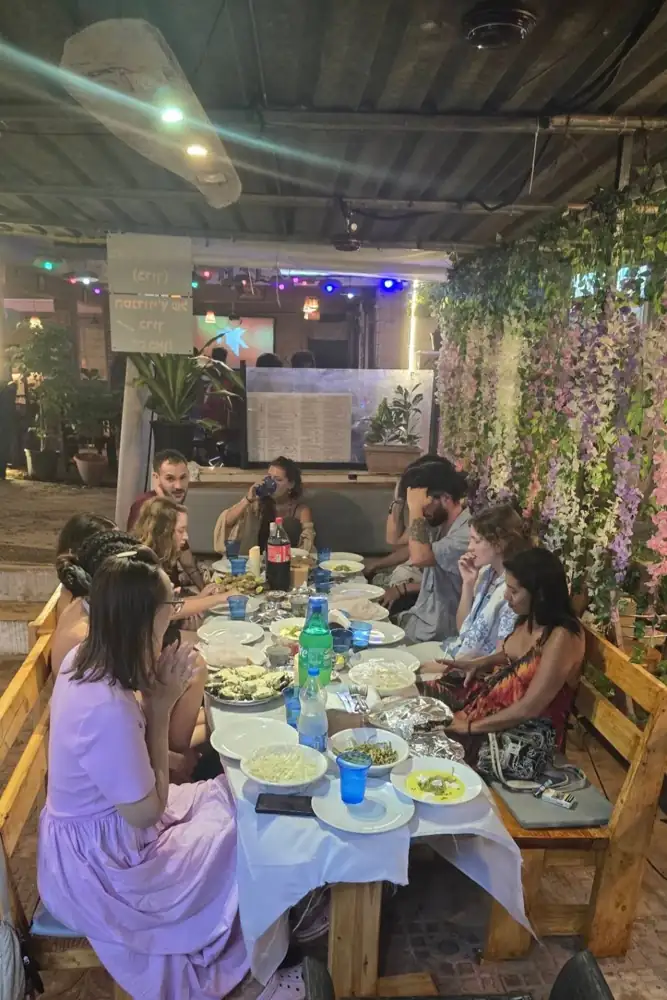 מטיילים סביב שולחן במסעדה של ברוך
